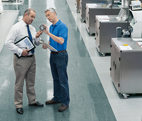 Two men speaking in a factory